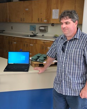 Chris Gillen, CEO of Total Support Solutions, helping to install the Gitsegukla library.
